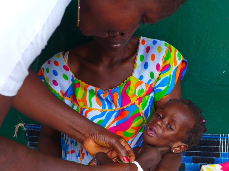 Madre con in braccio il bambino che piange dal medico nel progetto UNICEF